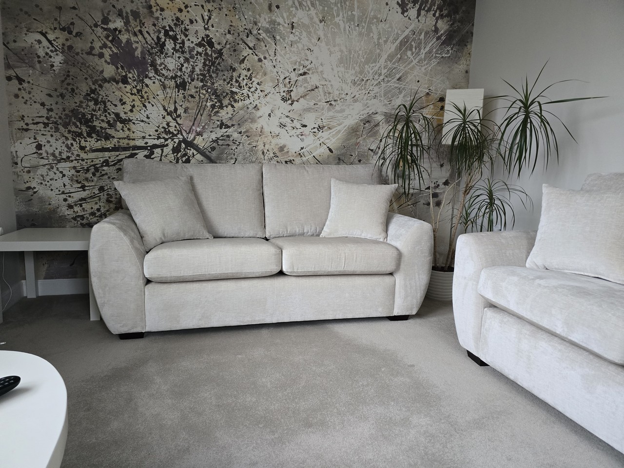 Cream Archer’s sofa against an abstract feature wall