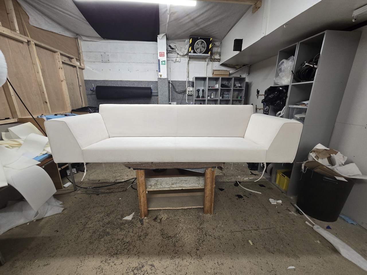 White-covered sofa body on a workshop bench