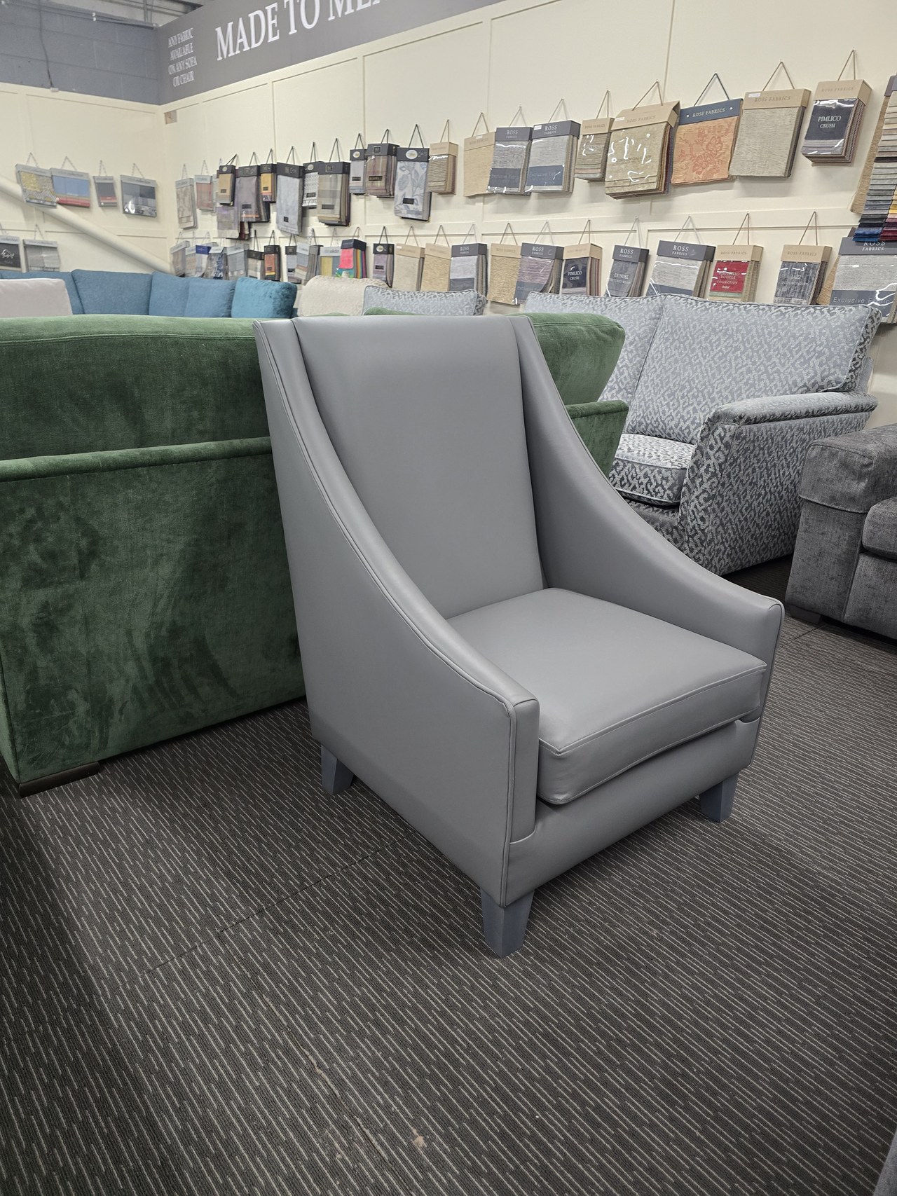 Grey Brinsworth chair with a tall back, sweeping curved arms and a single seat cushion.