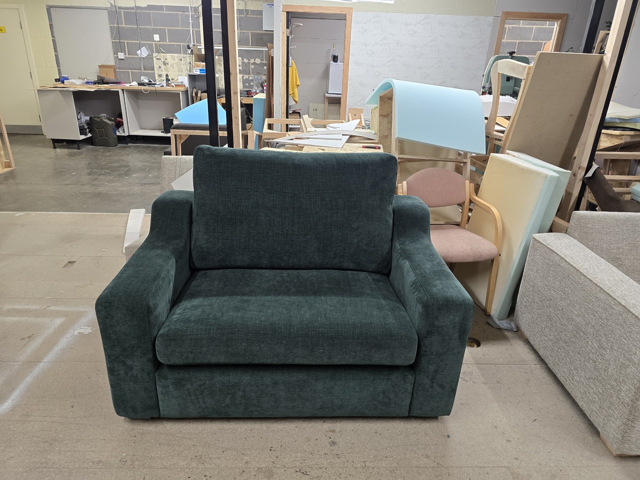 Teal Carla chair with narrow angled arms and a single seat and back cushion.