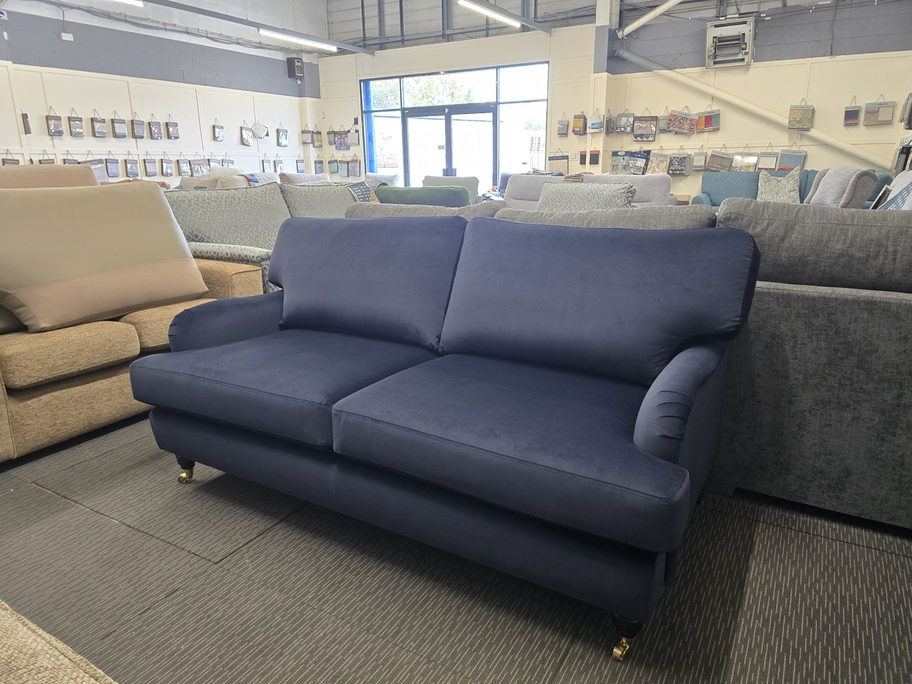 Dark blue Club sofa with two back cushions, two seat cushions and slim curved arms.