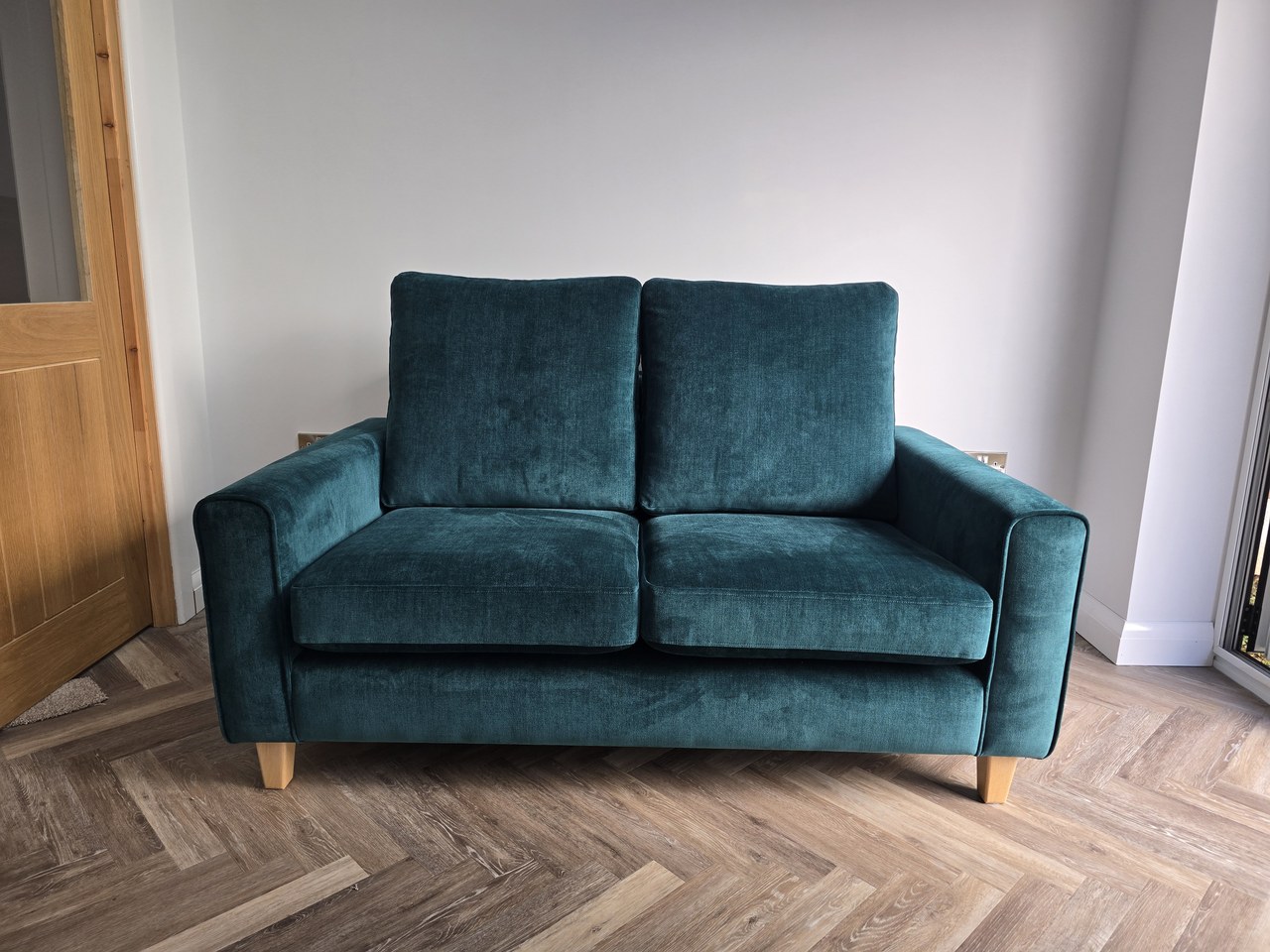 Teal Enzo sofa with two back cushions, slim arms and short tapered feet.