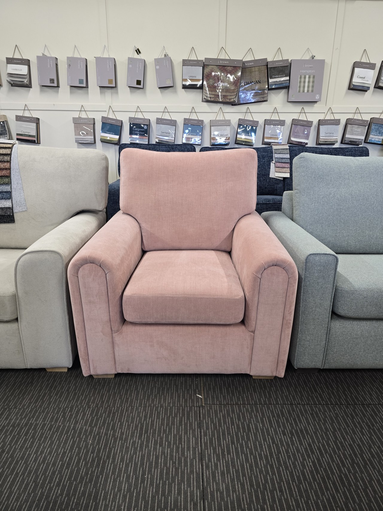 Pink Spitfire armchair with rounded arms and piped front panels.
