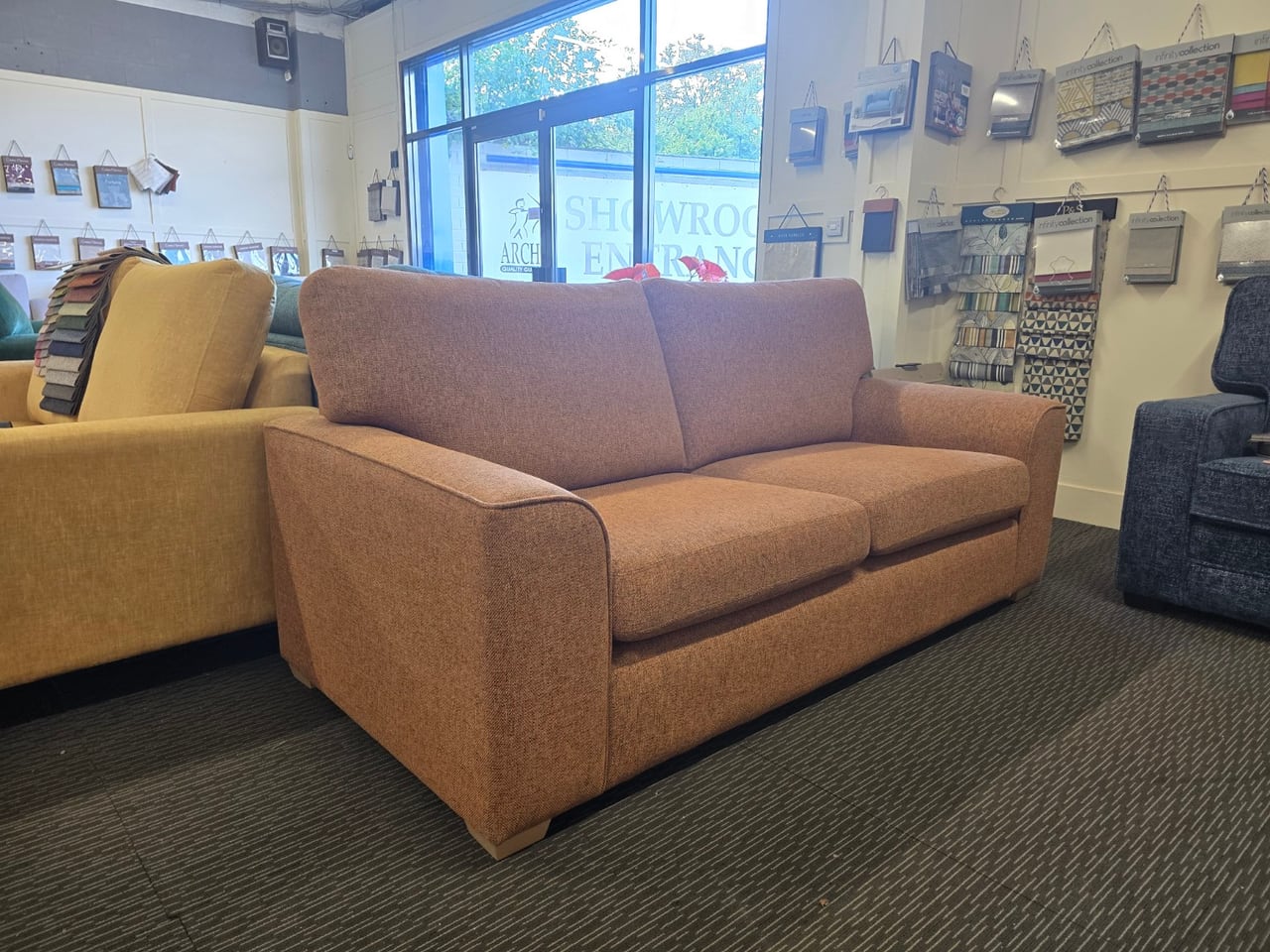 Three-quarter view of the orange Otto sofa with shaped arms