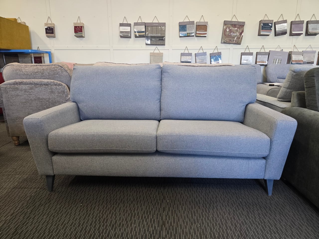 Grey blue Sorrento three-seater seen from the front in the showroom